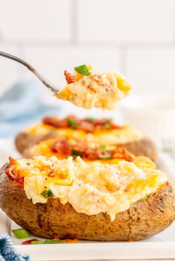 A fork lifts a bite from a Twice Baked Potato.