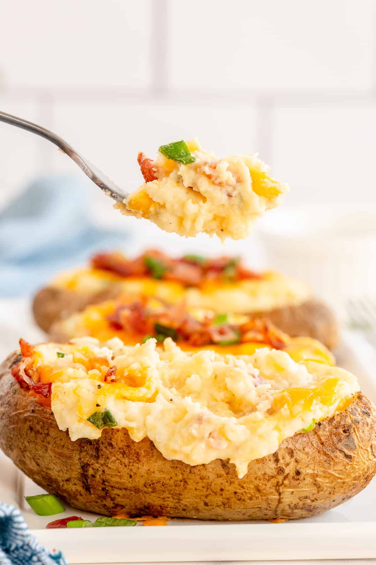 A fork lifts a bite from a stuffed potato.