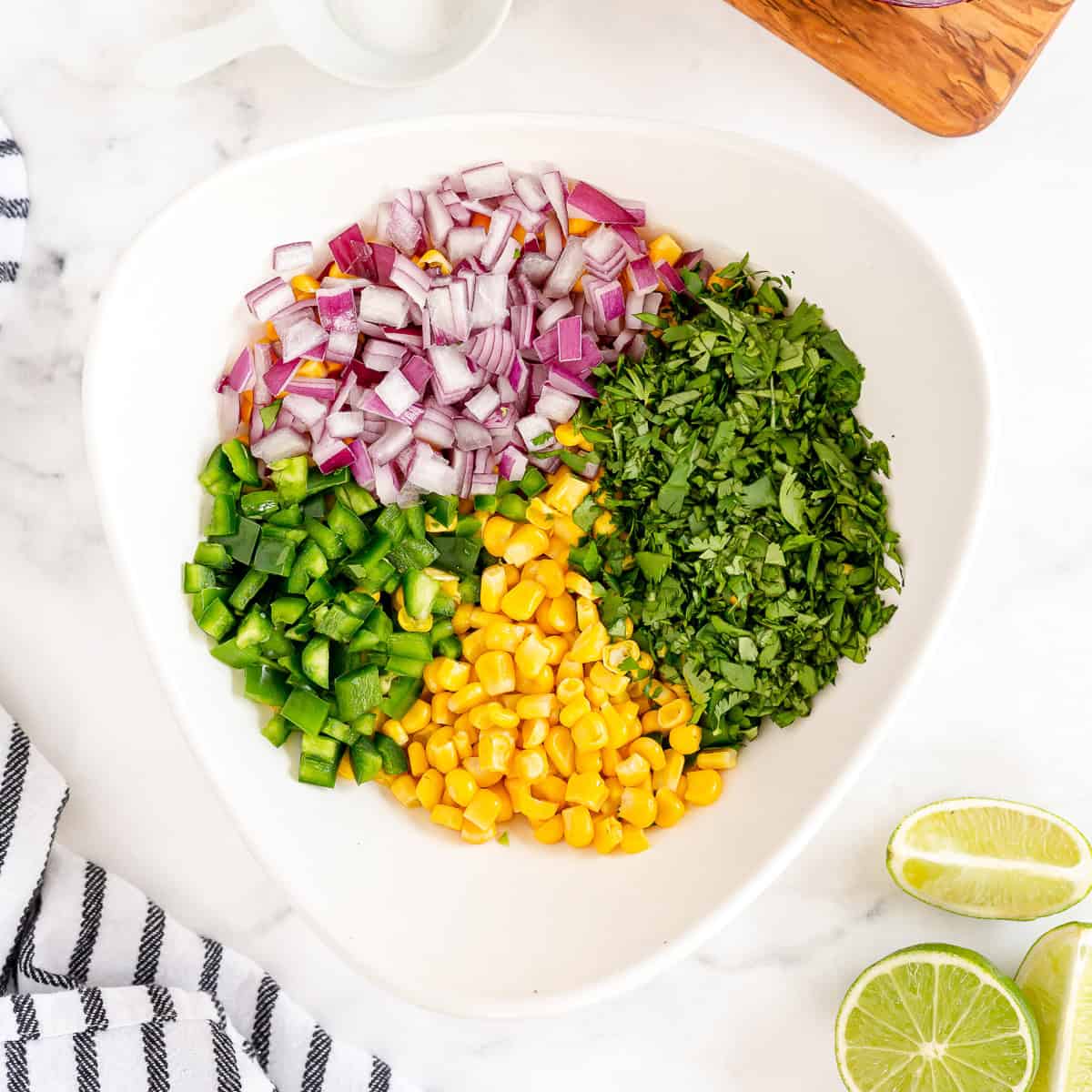 Ingredients for Chipotle corn salsa including sweet corn, red onion, jalape&ntilde;o, and cilantro,