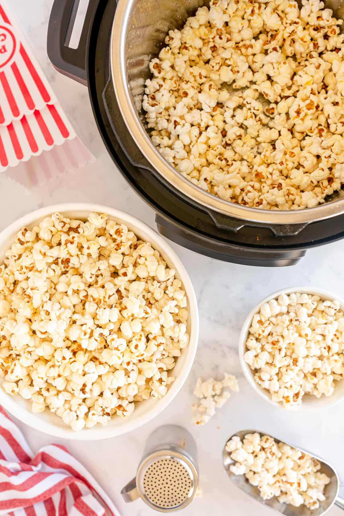 An Instant Pot and bowls filled with popcorn shot from over the top.