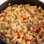 A skillet full of fusilli pasta with ground beef and peppers.