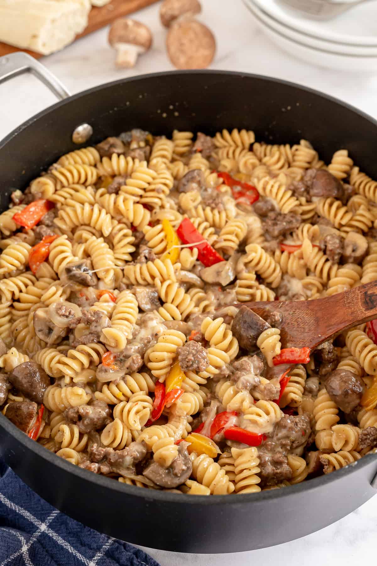 A skillet full of fusilli pasta with ground beef and peppers.