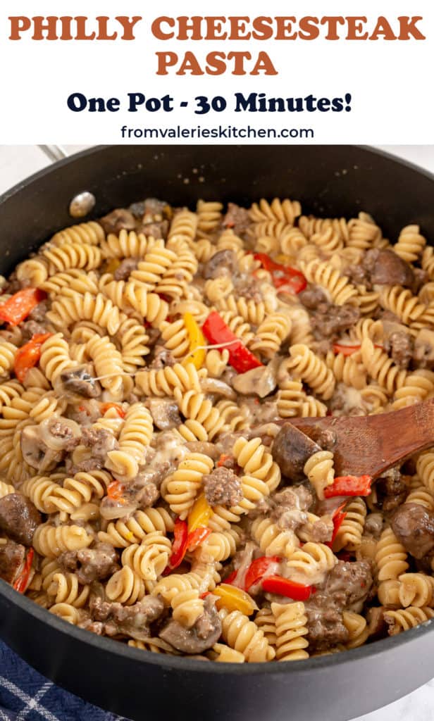 A skillet full of Philly Cheesesteak pasta with text overlay.