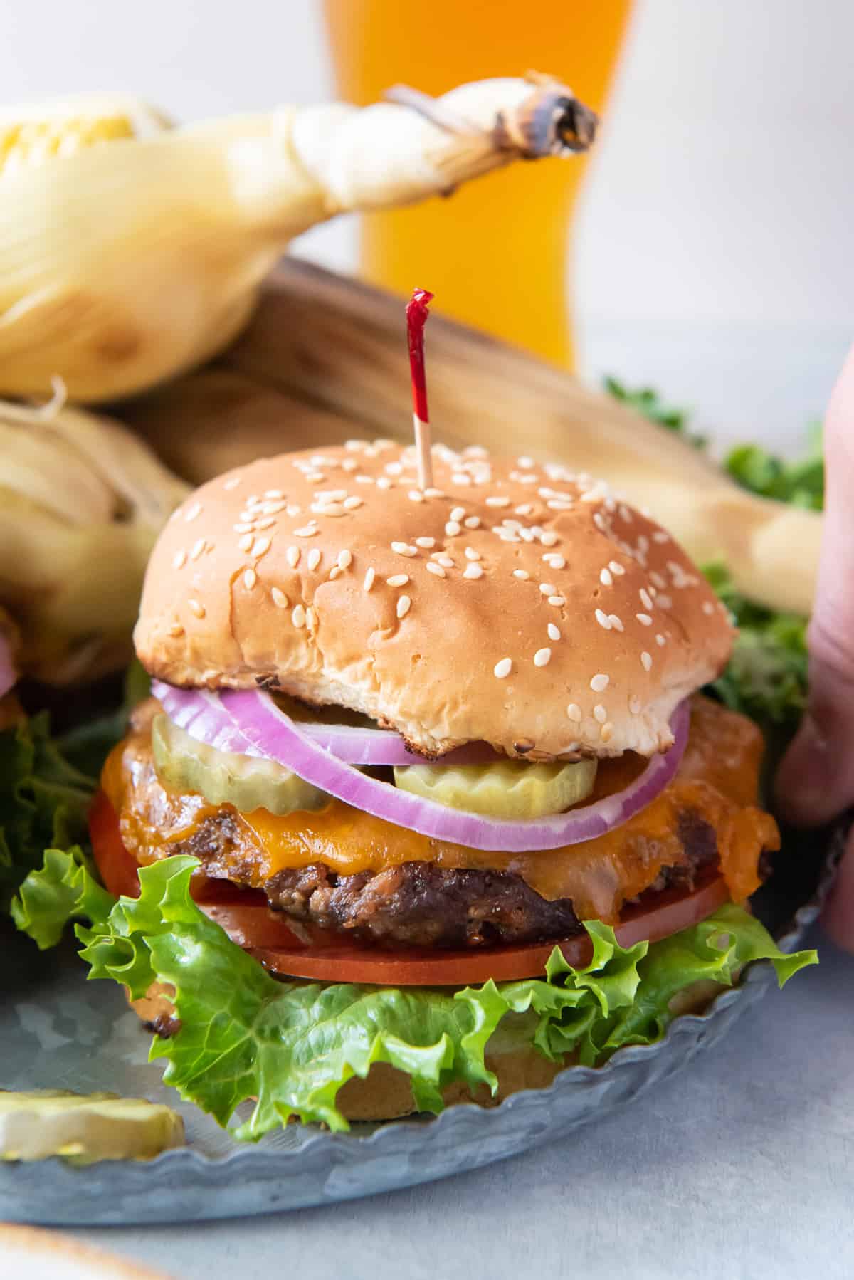 A closeup of a burger on a metal platter.