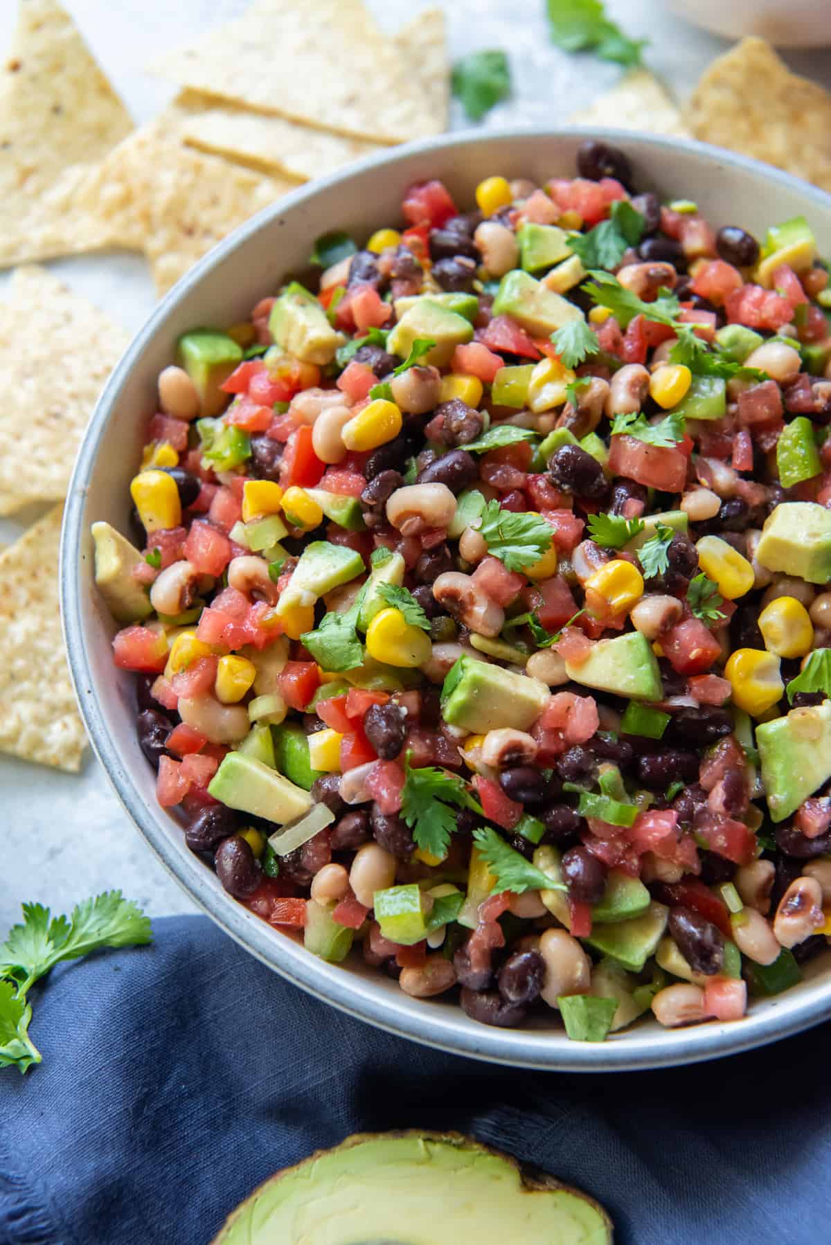 Tomatoes, black eyed peas, corn and other ingredients in a bowl.