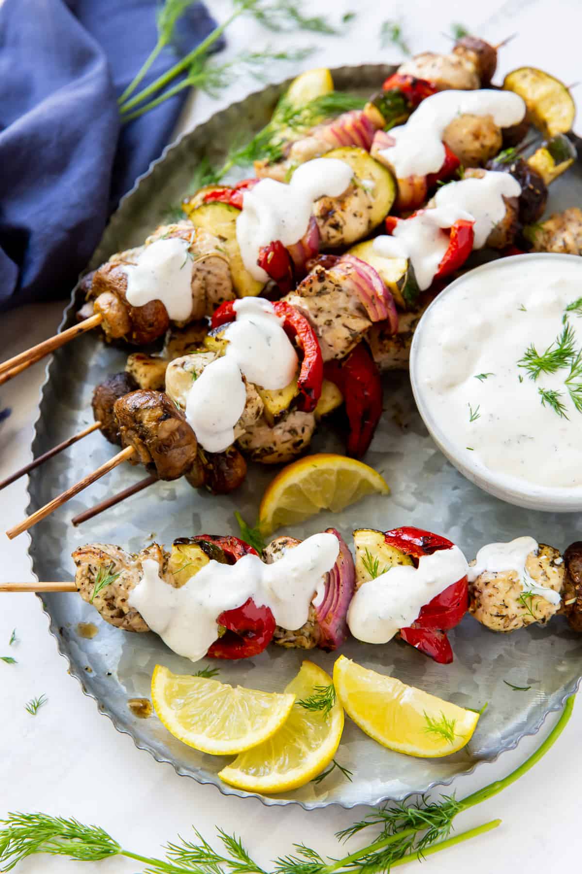 Chicken kabobs with Feta Dill Sauce spooned over the top.