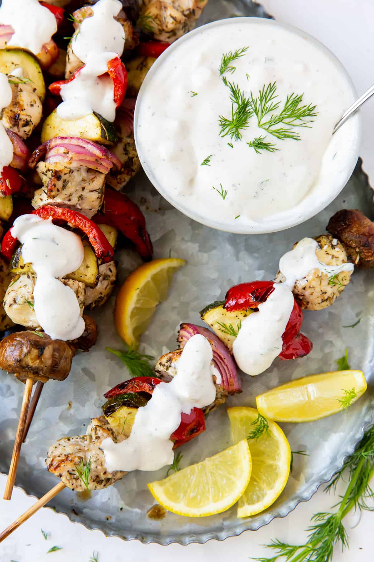 Greek Chicken Kabobs with Feta Dill Sauce spooned over the top.