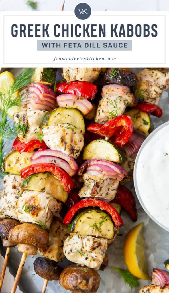A closeup of Greek Chicken Kabobs on a silver platter with text overlay.