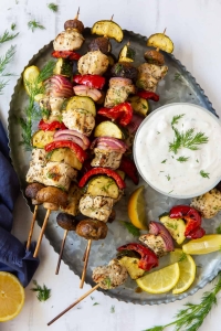 Greek Chicken Kabobs on a silver platter with Feta Dill Sauce.