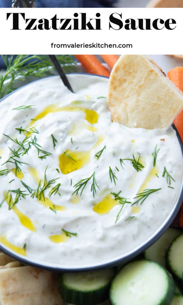 A close up of a bowl of Tzatziki drizzled with olive oil with overlay text.
