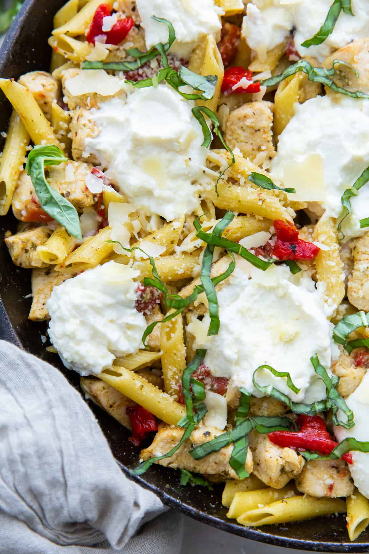 A closeup of Chicken Pesto Pasta in a cast iron skillet.