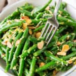 A fork digs into a bowl of Pesto Green Beans.
