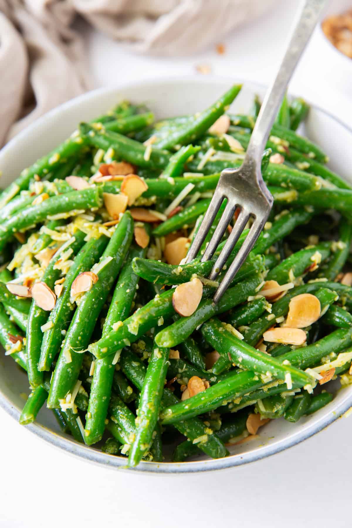 A fork digs into a bowl of Pesto Green Beans.