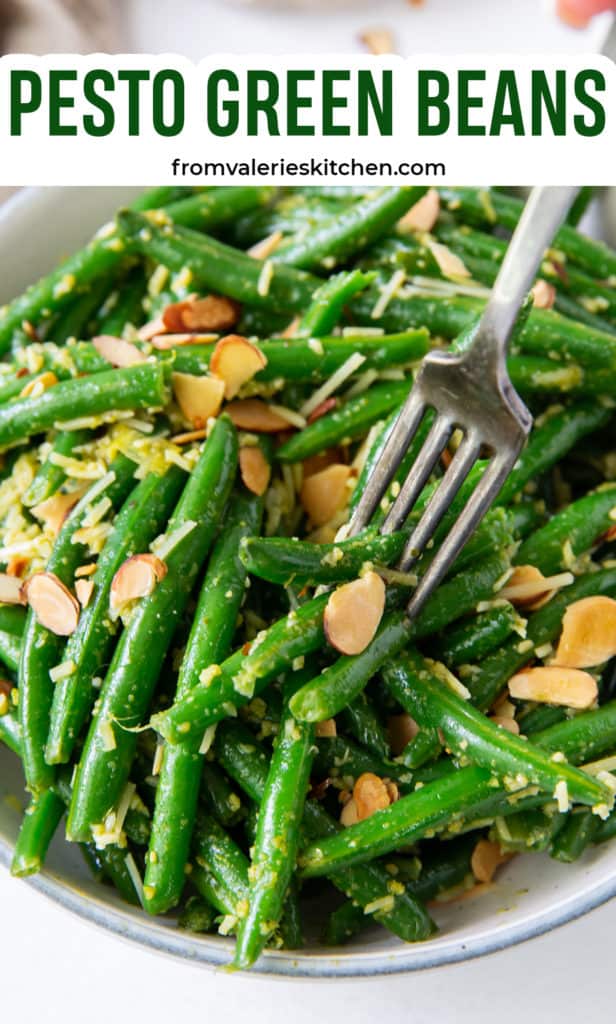 A fork digs into a bowl of Pesto Green Beans with text overlay.