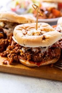 A closeup of a Pizza Joe with a wooden pick in it on a cutting board.