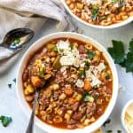 An over the top shot of two bowls of Hamburger Minestrone topped with Parmesan.