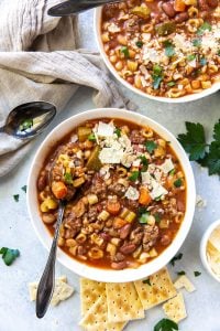 An over the top shot of two bowls of Hamburger Minestrone topped with Parmesan.