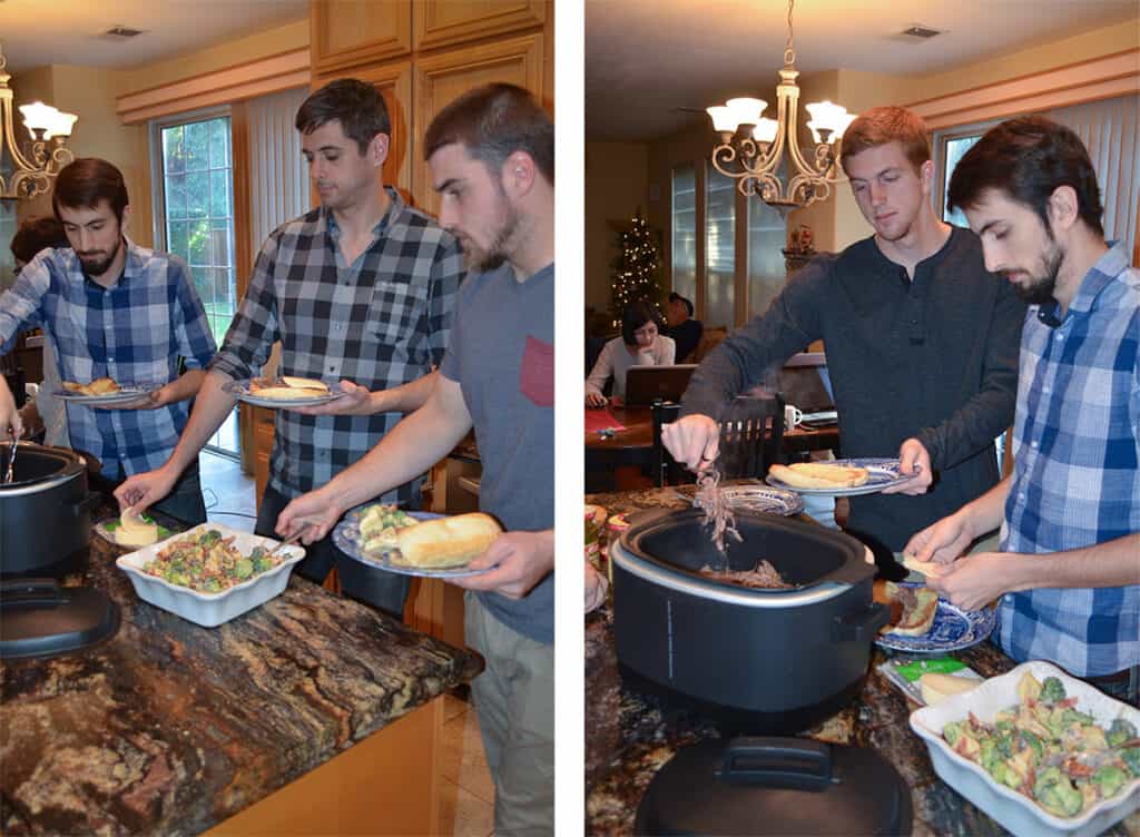 Four young men making sandwiches at a kitchen counter.