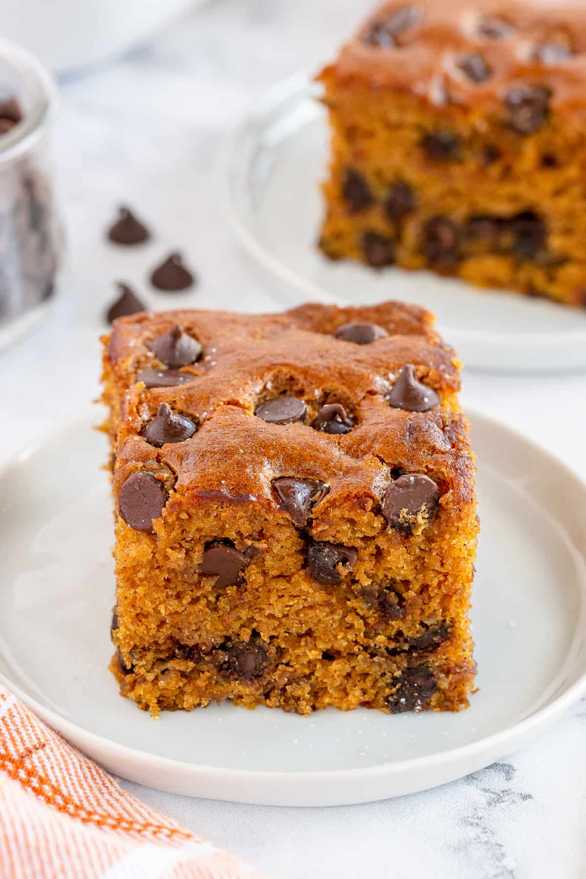 A slice of pumpkin chocolate chip cake on a white plate.