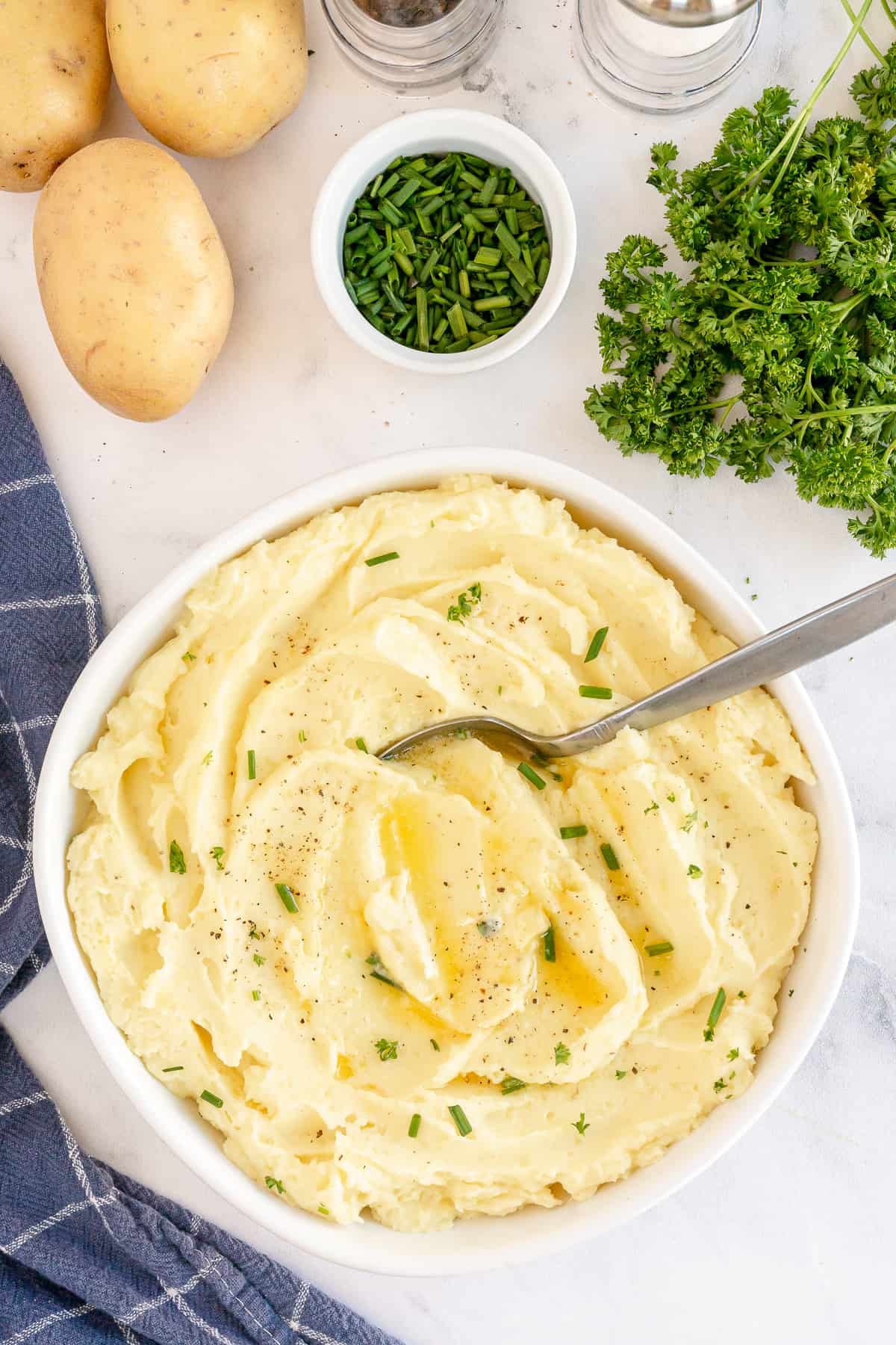 An over the top shot of a bowl of mashed potatoes with a spoon in it.