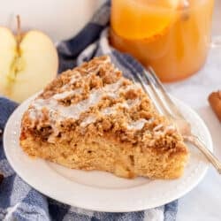 A slice of Apple Cider Coffee Cake on a white plate with a fork.