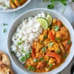 Coconut Curry Chicken in a bowl with rice and a lime wedge.