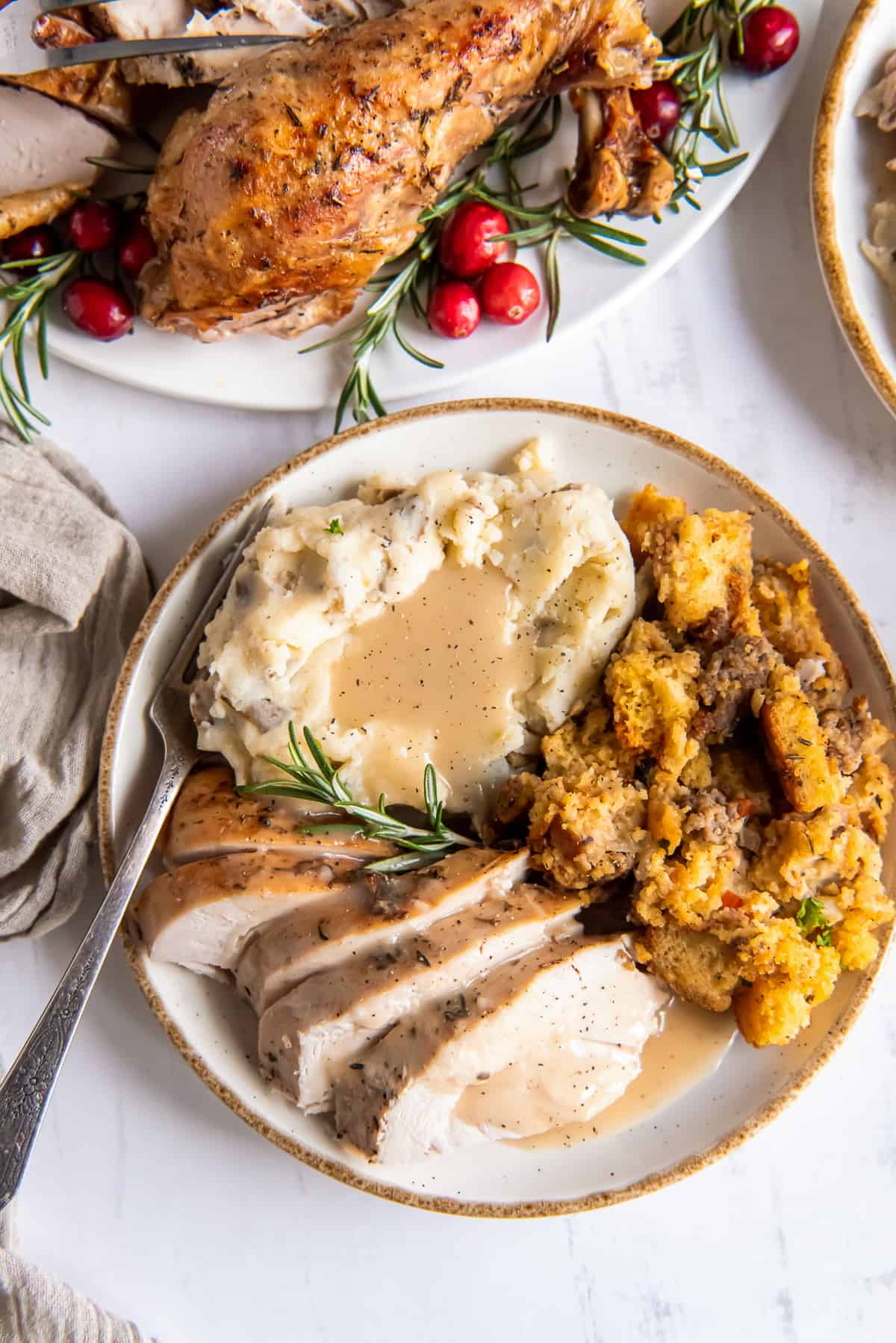 A plate with sliced turkey, gravy, mashed potatoes and stuffing.