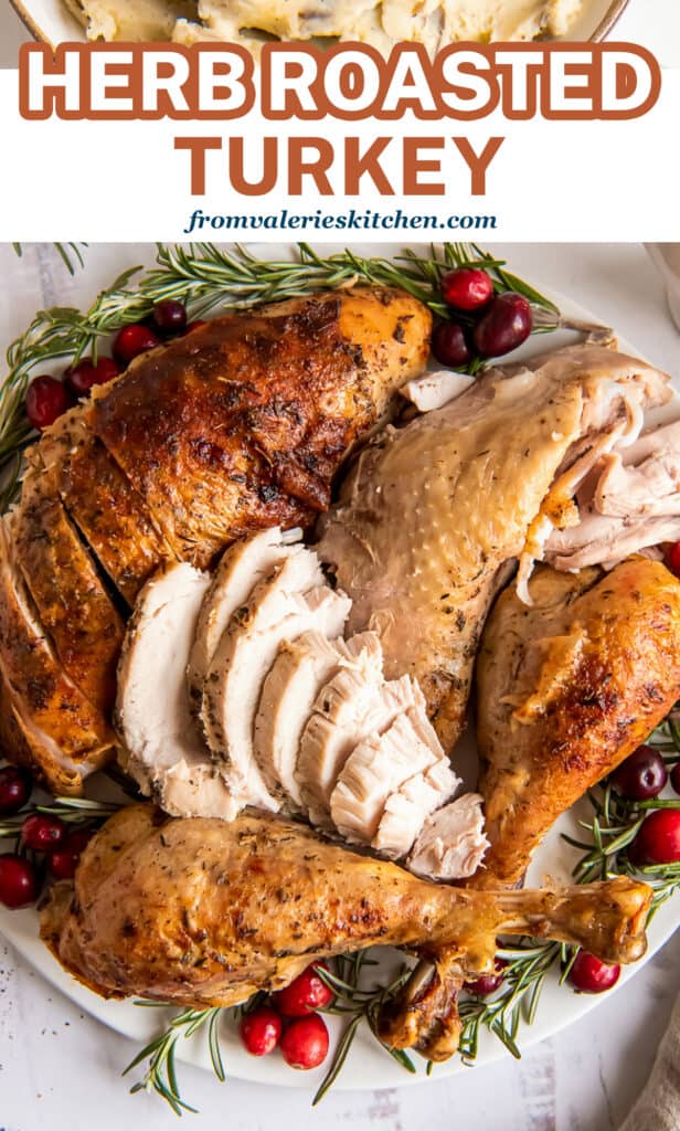 A platter of turkey with overlay text Herb Roasted Turkey.