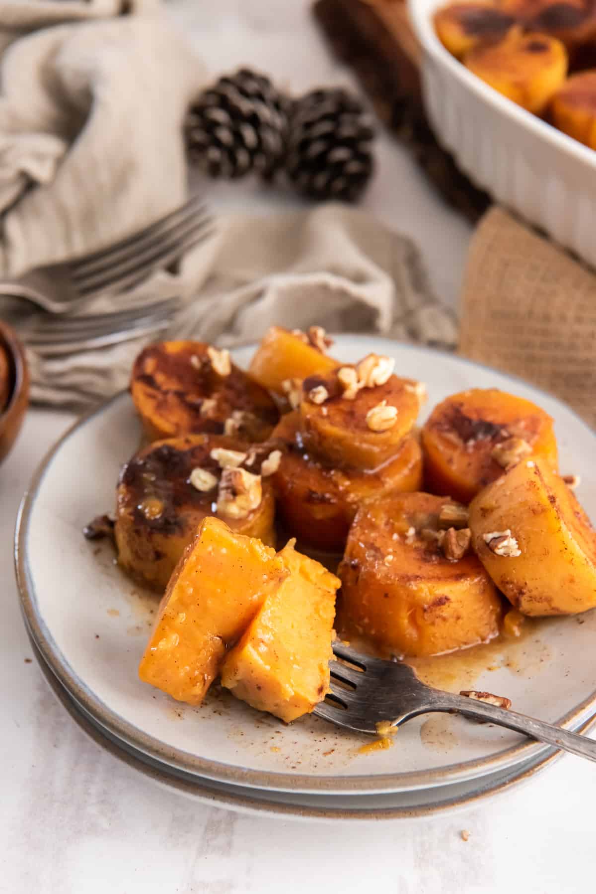 A fork with pieces of sweet potato on a small plate.