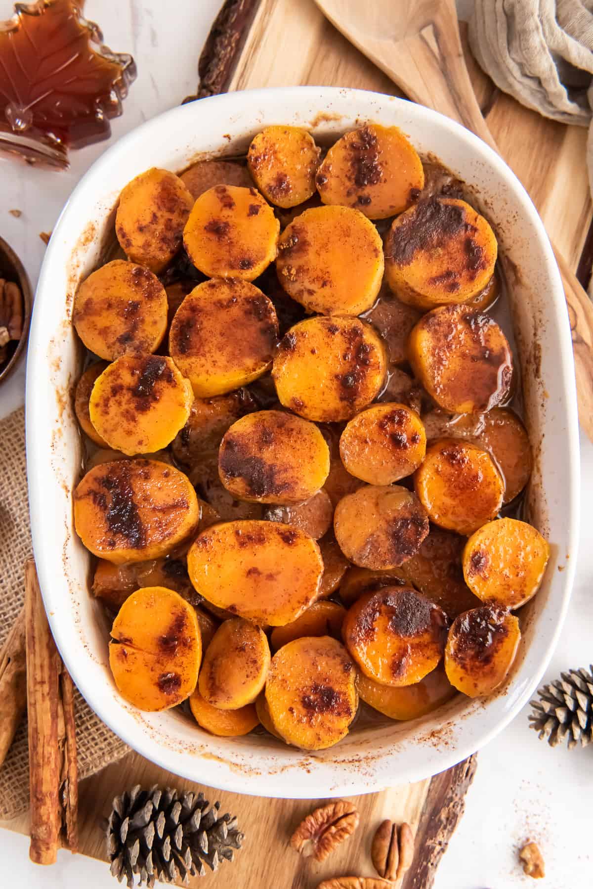 An over the top shot of Maple Glazed Sweet Potatoes in a white baking dish.