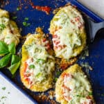 Baked Chicken Pesto Parmesan on a blue baking sheet.