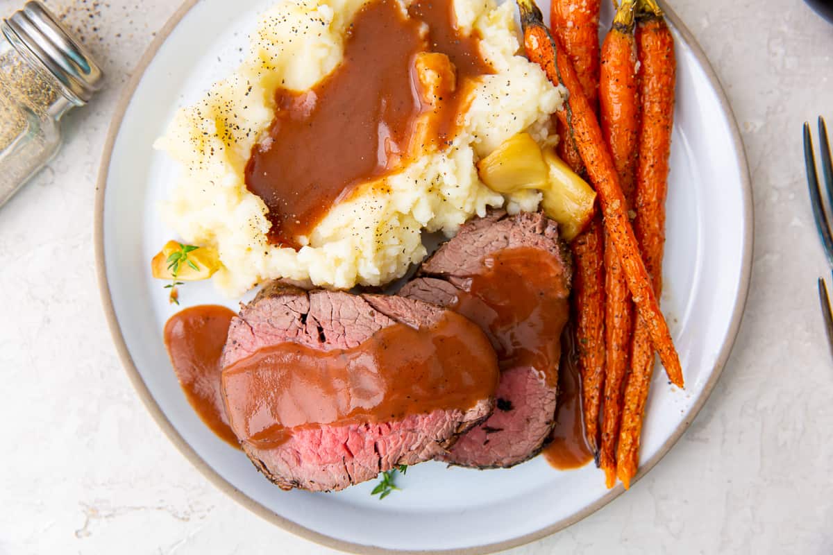 Port wine gravy over slices of beef tenderloin and mashed potatoes.