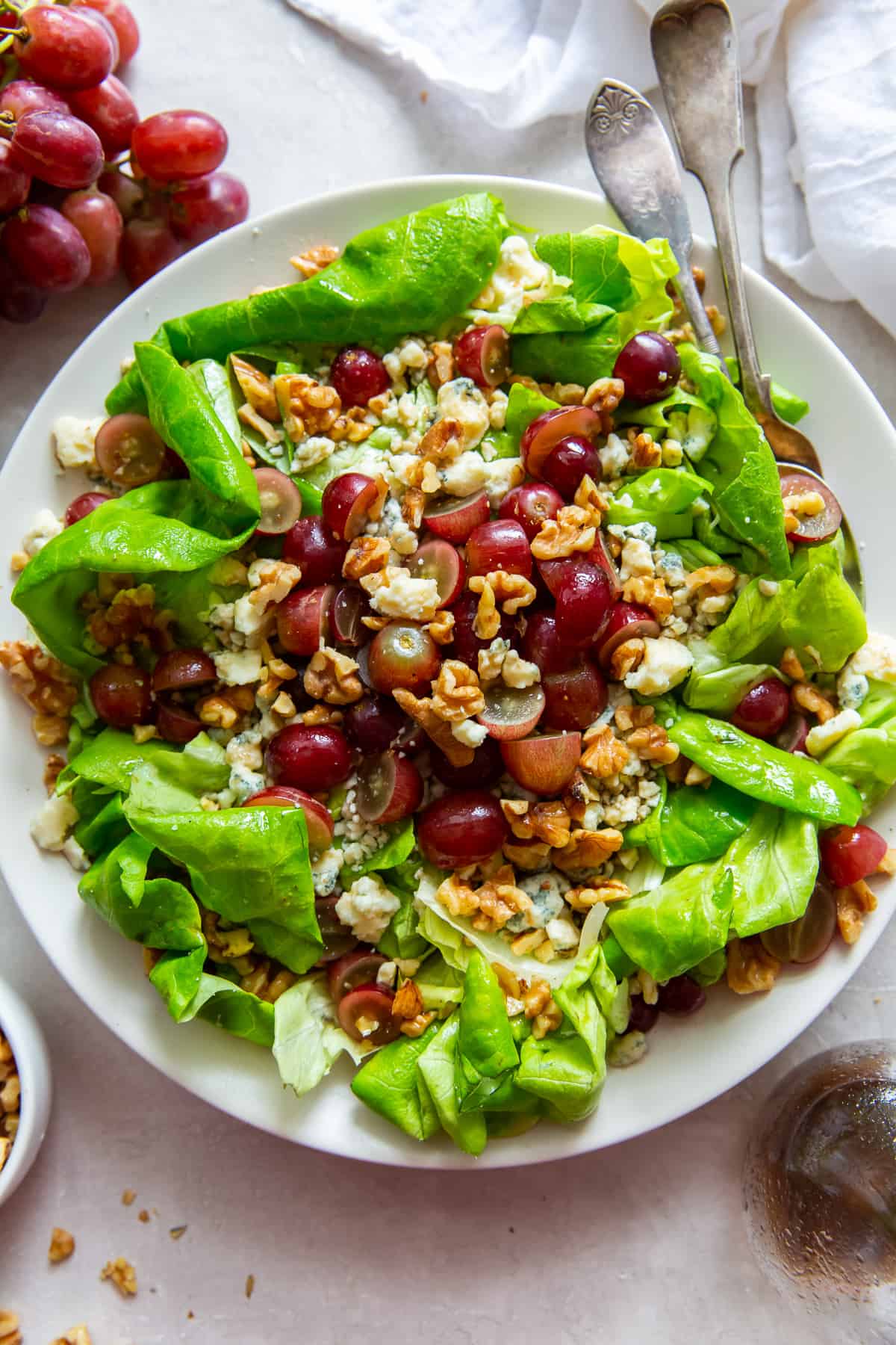 An over the top shot of butter lettuce salad on a white plate.