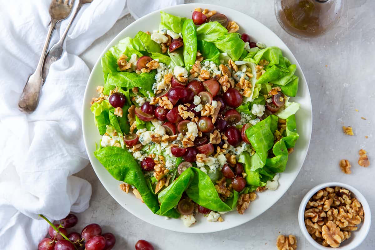 An over the top shot of  salad with grapes, gorgonzola, and walnuts.