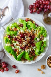 An over the top shot of butter lettuce salad with grapes, gorgonzola and walnuts.