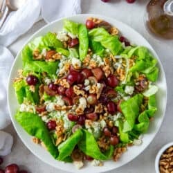 An over the top shot of butter lettuce salad with grapes, gorgonzola and walnuts.