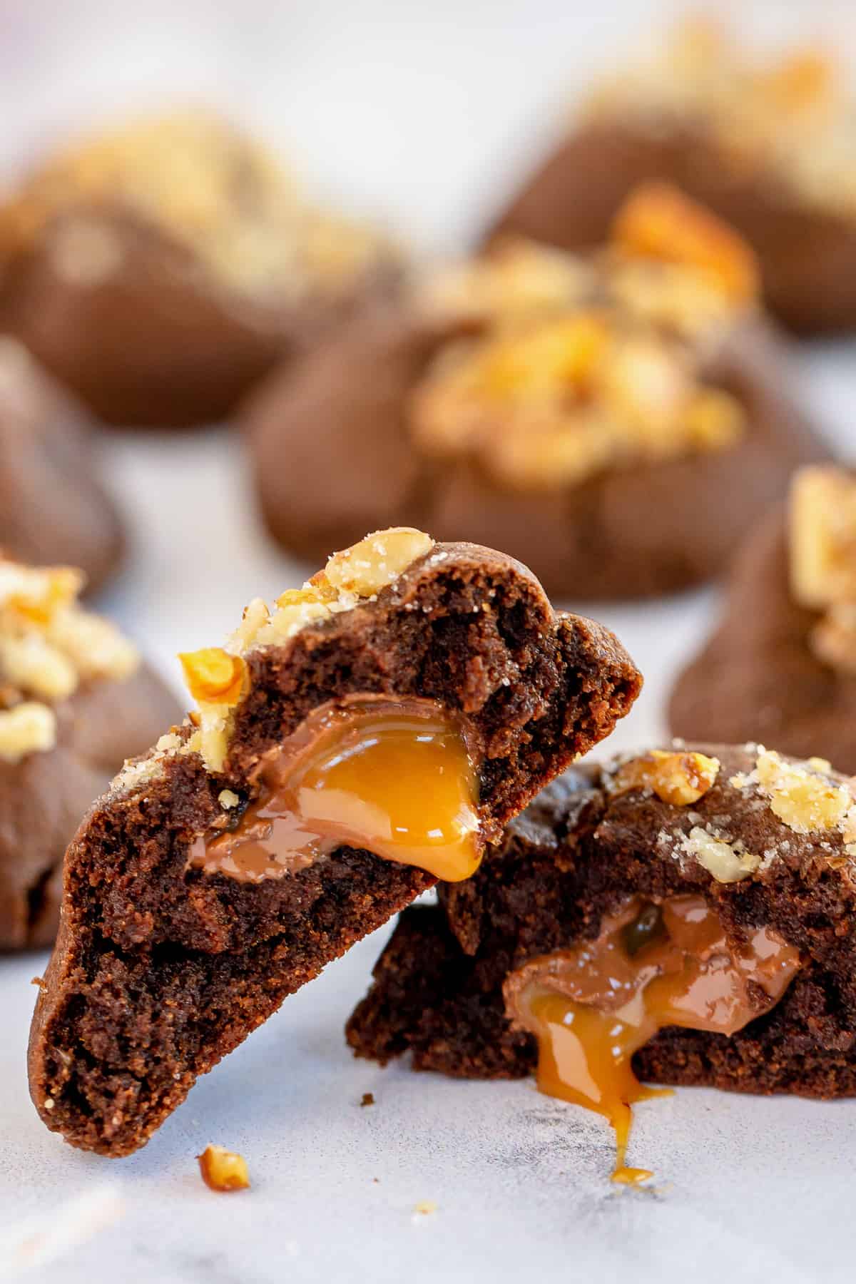 A chocolate cookies cut in half with caramel oozing out.