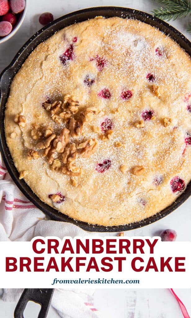 An over the top shot of Cranberry Breakfast Cake in a cast iron skillet with overlay text.