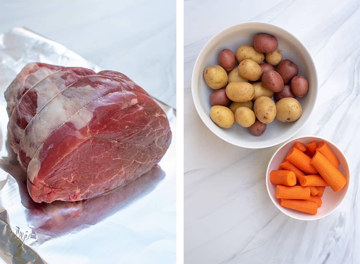 A chuck roast on foil and carrots and potatoes in white bowls.