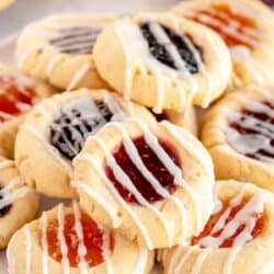 A pile of Jam Thumbprint Cookies topped with glaze.