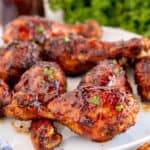 A close up of a platter of BBQ Chicken Drumsticks in front of parsley.