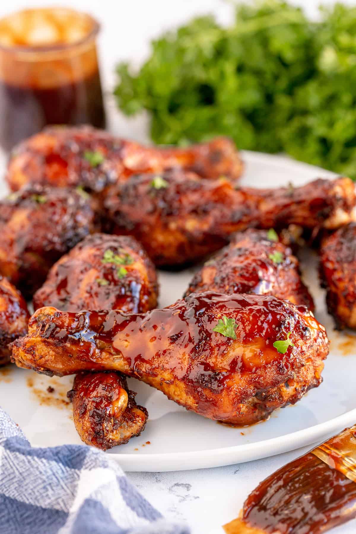 A close up of a platter of BBQ Chicken Drumsticks in front of parsley.