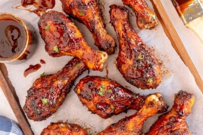 BBQ chicken drumsticks on a parchment paper lined board.