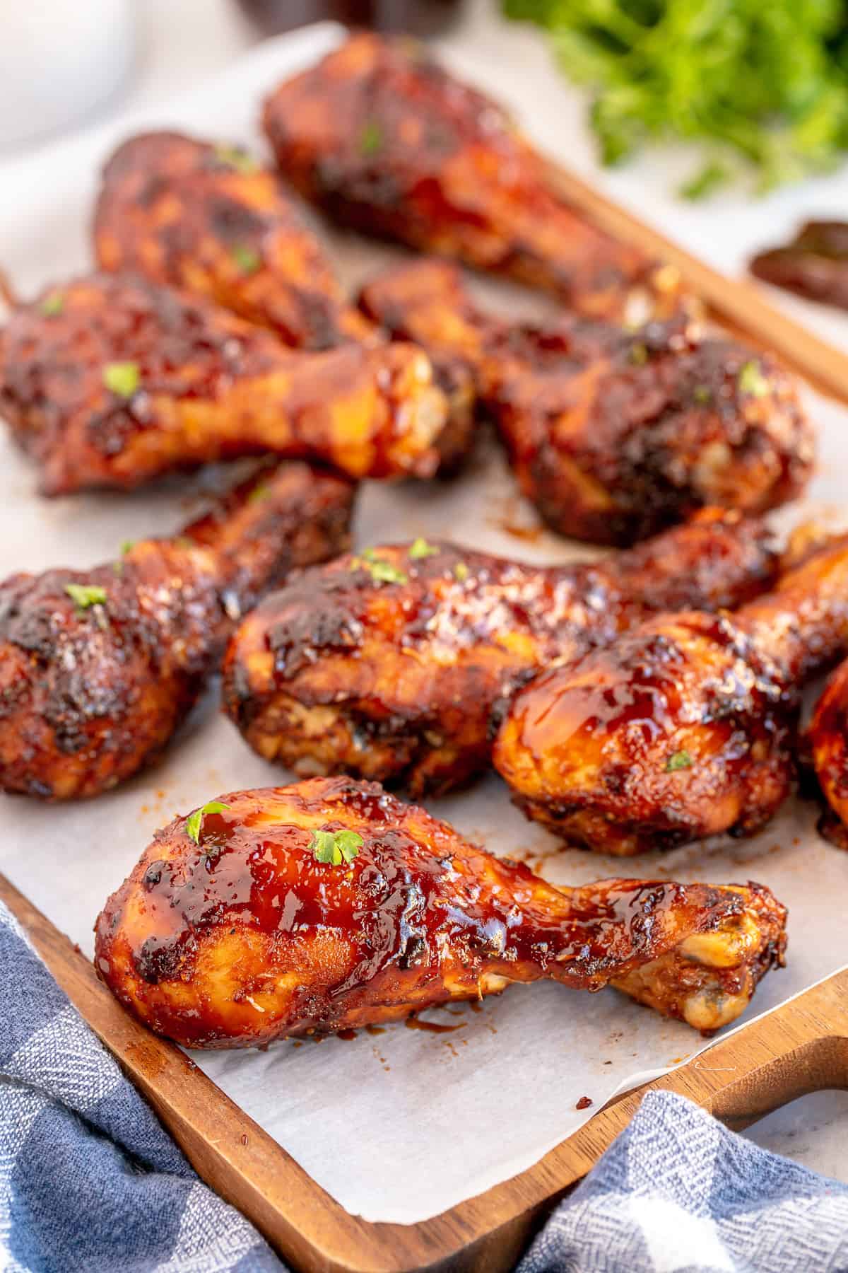 Air Fryer Chicken Drumsticks with BBQ Sauce on parchment paper.