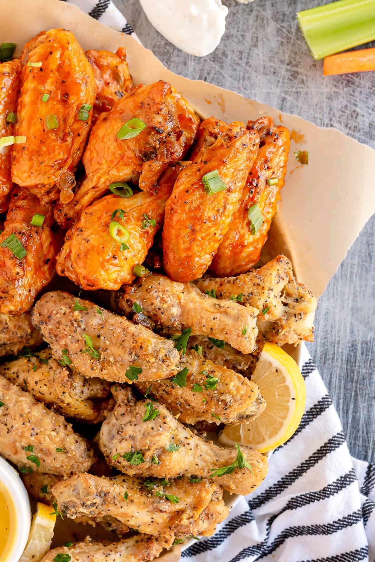 Lemon pepper and buffalo wings on a platter shot from over the top.