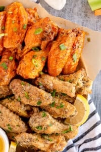 Buffalo and lemon pepper wings on a platter shot from over the top.