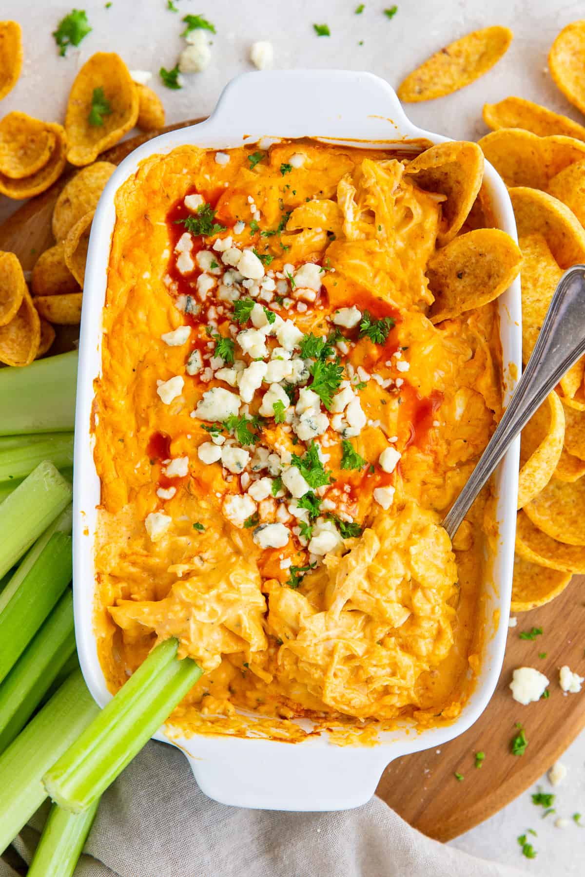 An over the top shot of Buffalo Chicken Dip with Frank's Red Hot Sauce in a white baking dish.