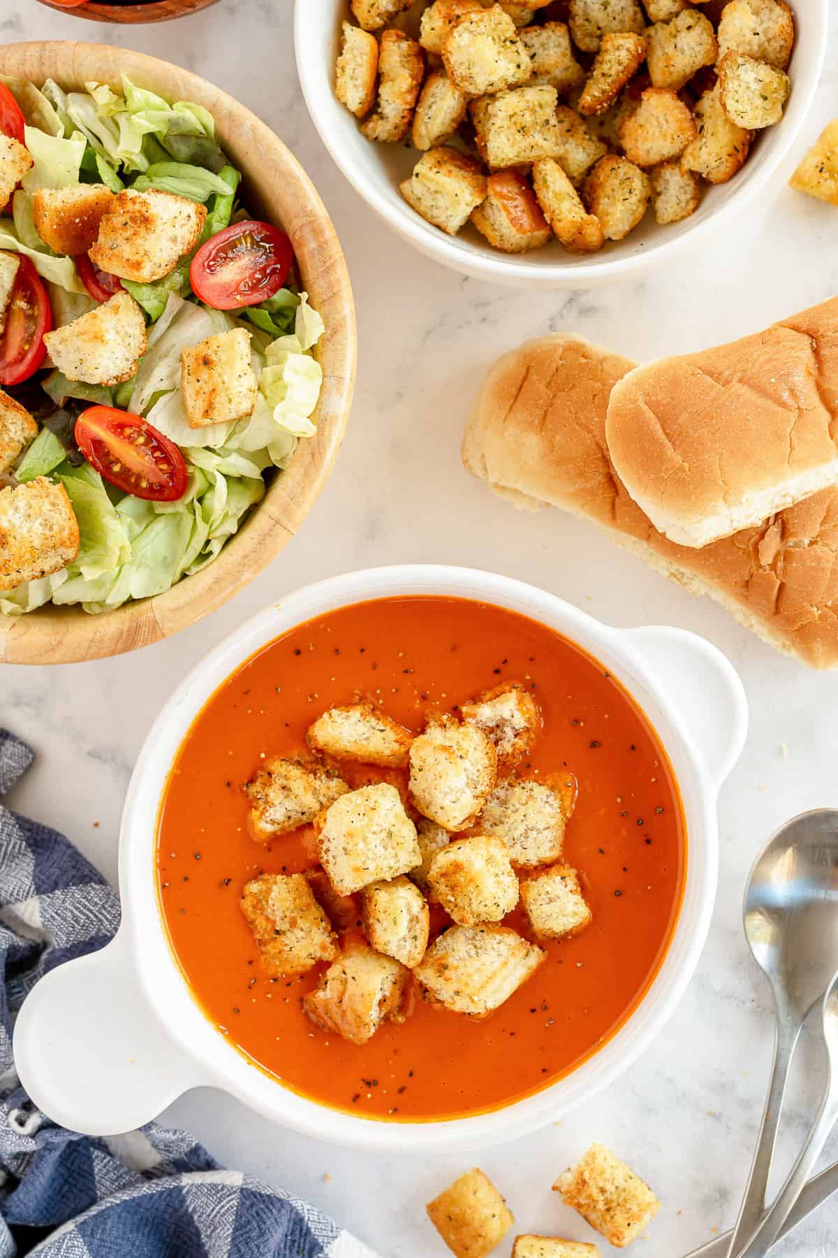 An over the top shot of a bowl of tomato soup with croutons.