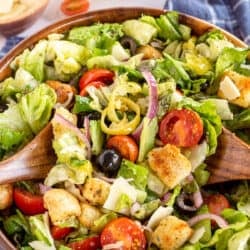 An Italian Salad with olives, tomatoes, onions and croutons.