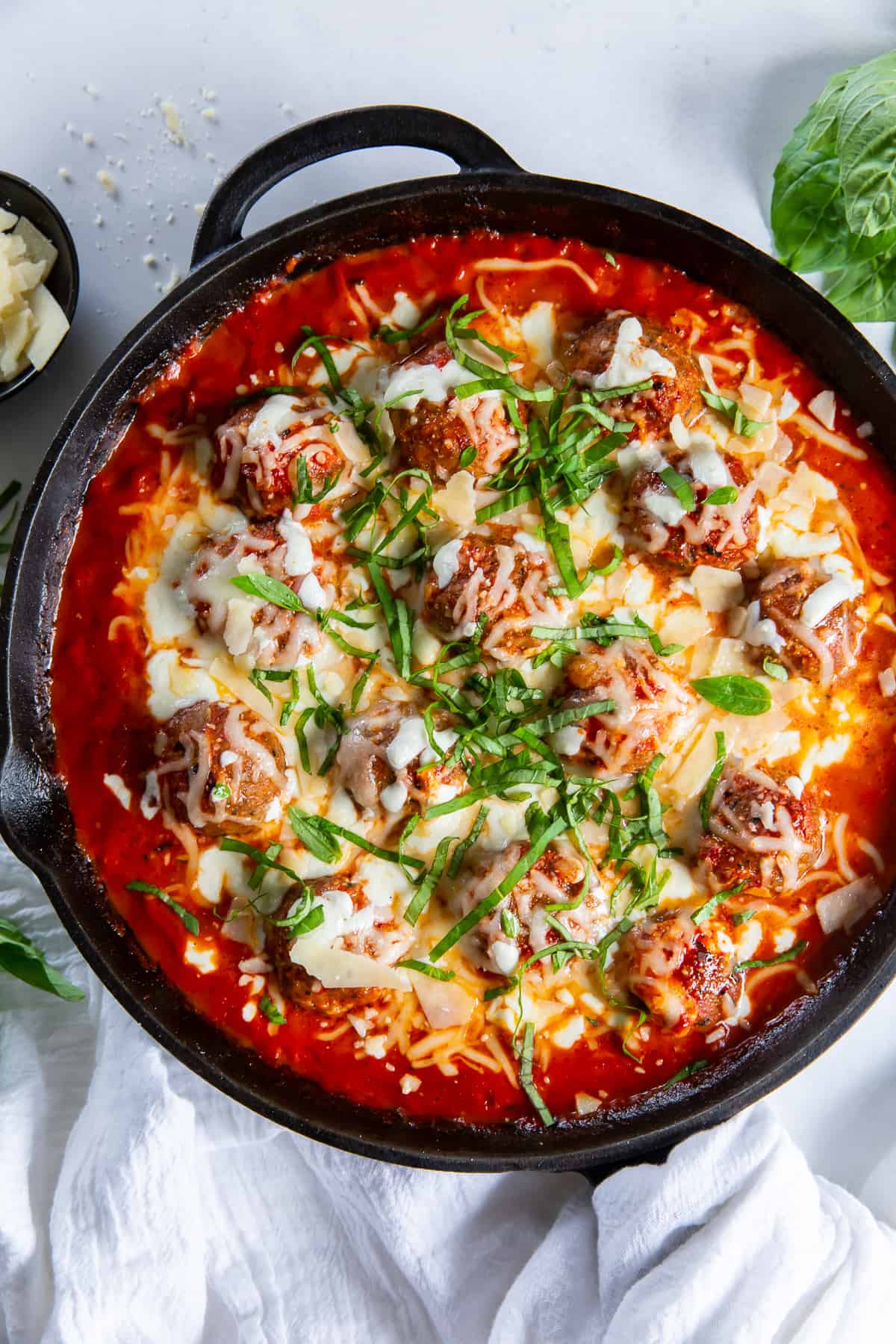 An over the top shot of turkey meatballs and tomato cream sauce in a skillet.